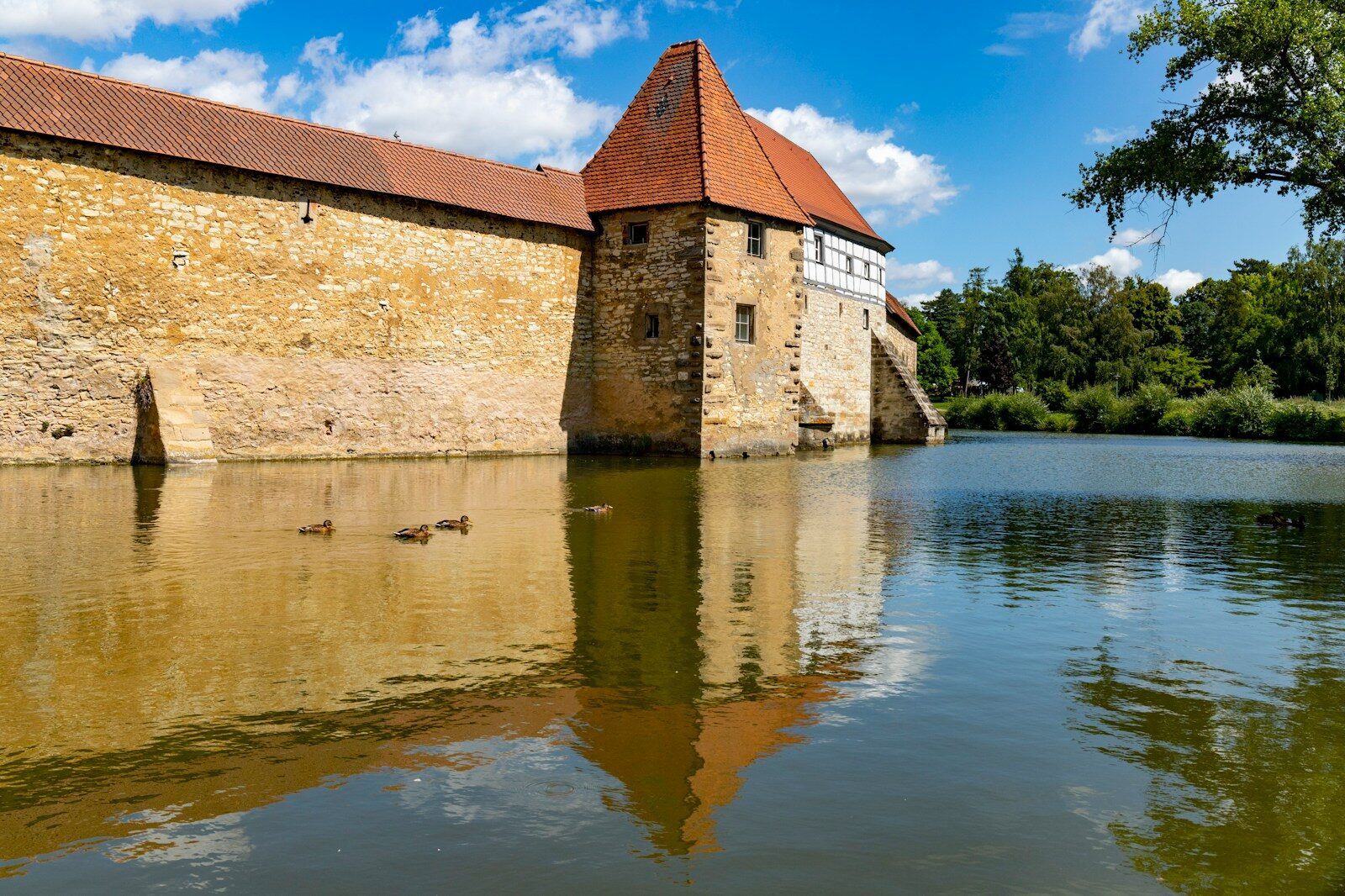 brown concrete building near body of water under blue sky during daytime