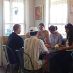 Group of friends sitting around a table indoors.